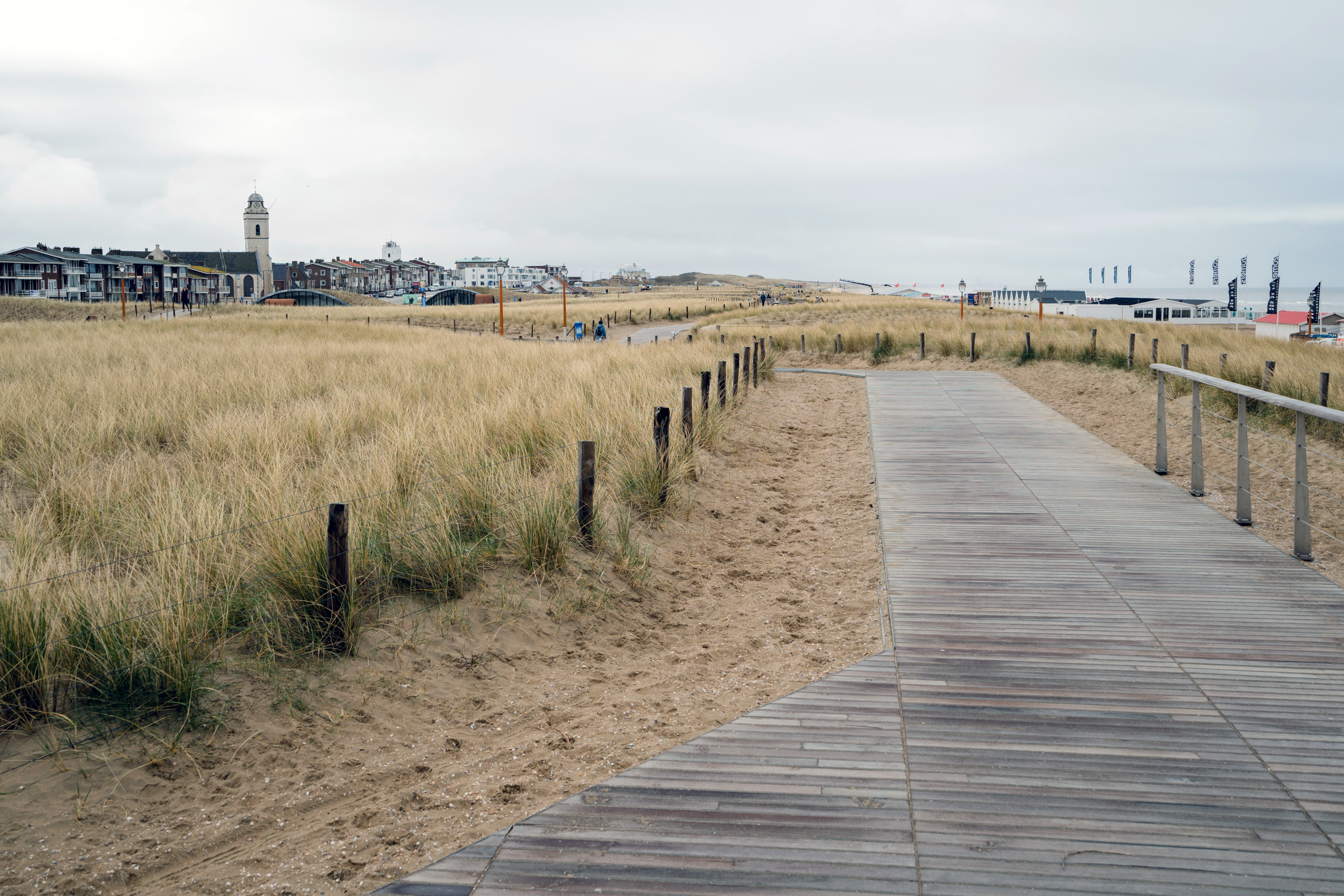 A walkway above the Katwijk multiuse dike, with the ocean to the right. A parking garage is beneath the dunes.