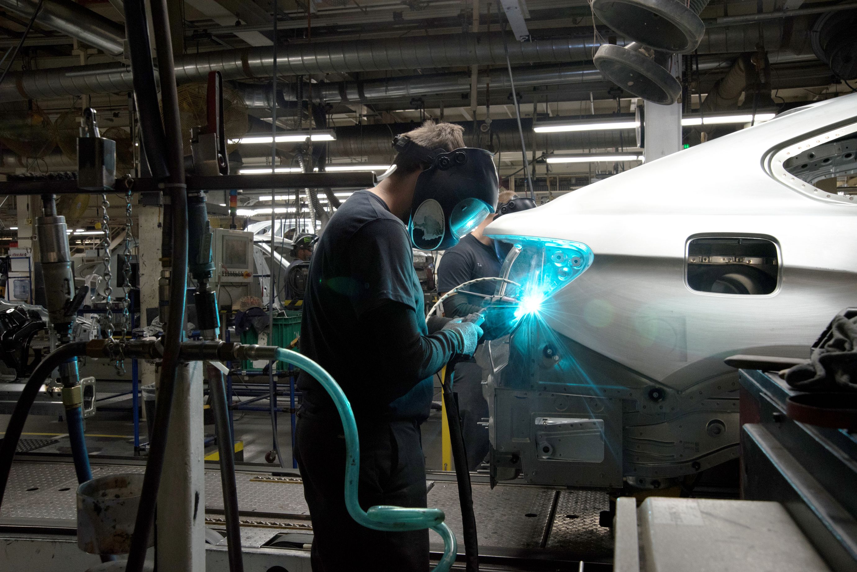 Most of the welding done in the plant's body shop is performed by robots, but certain special welds are still made by workers. (2 of 7)