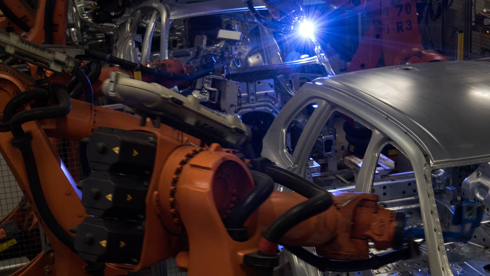 Robot welding in the body shop occurs in large cages to protect workers, who monitor the robots from afar. (4 of 7)