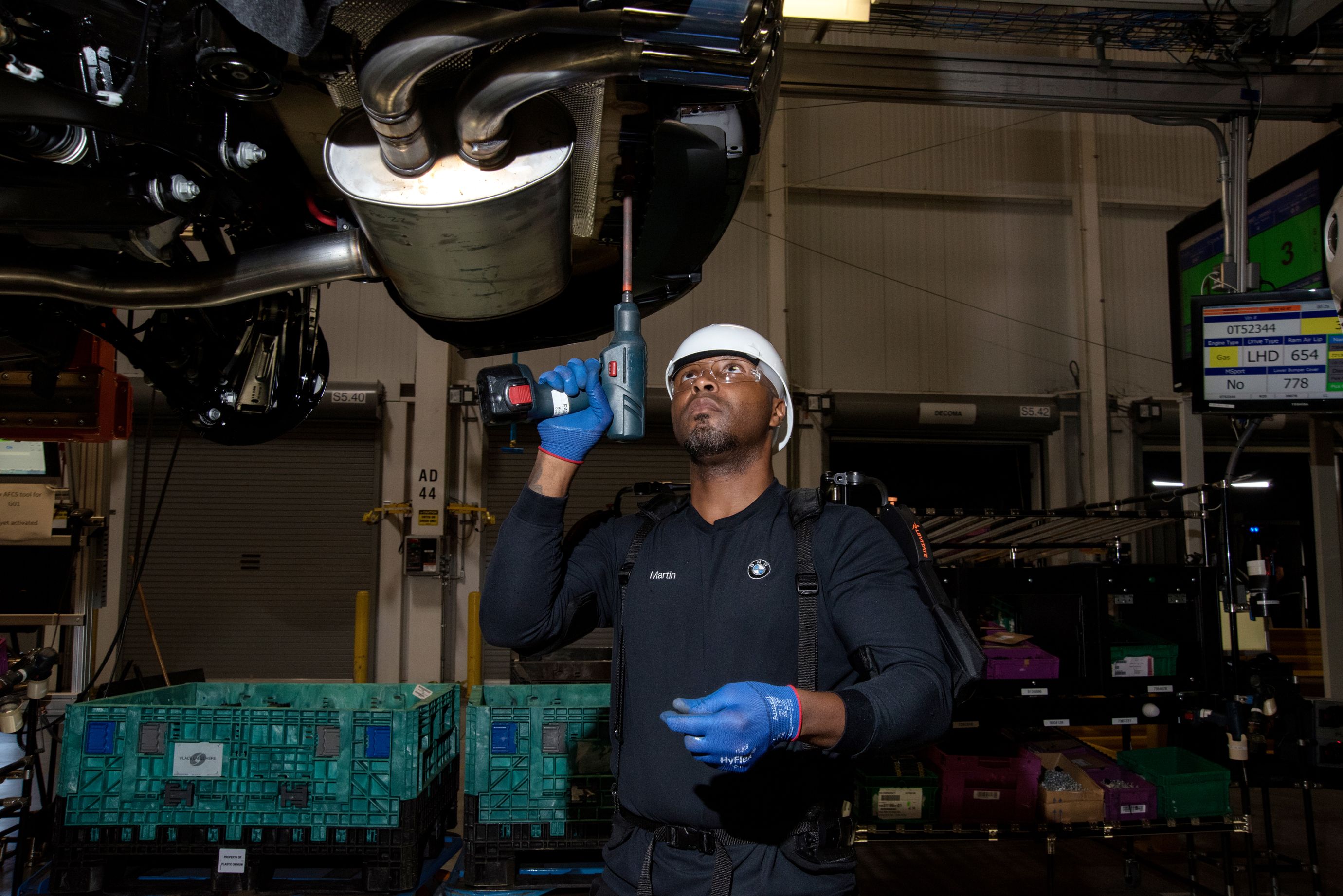 Assembly line worker Lee Martin fastens screws to the underbody of a car using an ergonomic arm support to reduce the strain of long periods working with his arms raised. (6 of 7)