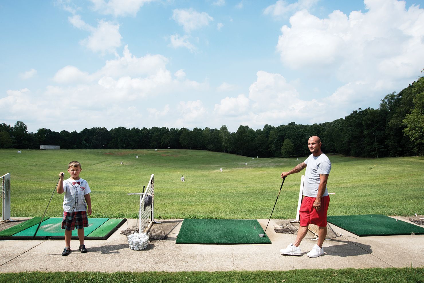 Wes Robida and his son Caden at the driving range on a Sunday afternoon. The family recently relocated from Denver to Greenville, attracted by the strong economy and cost of living. (1 of 10)