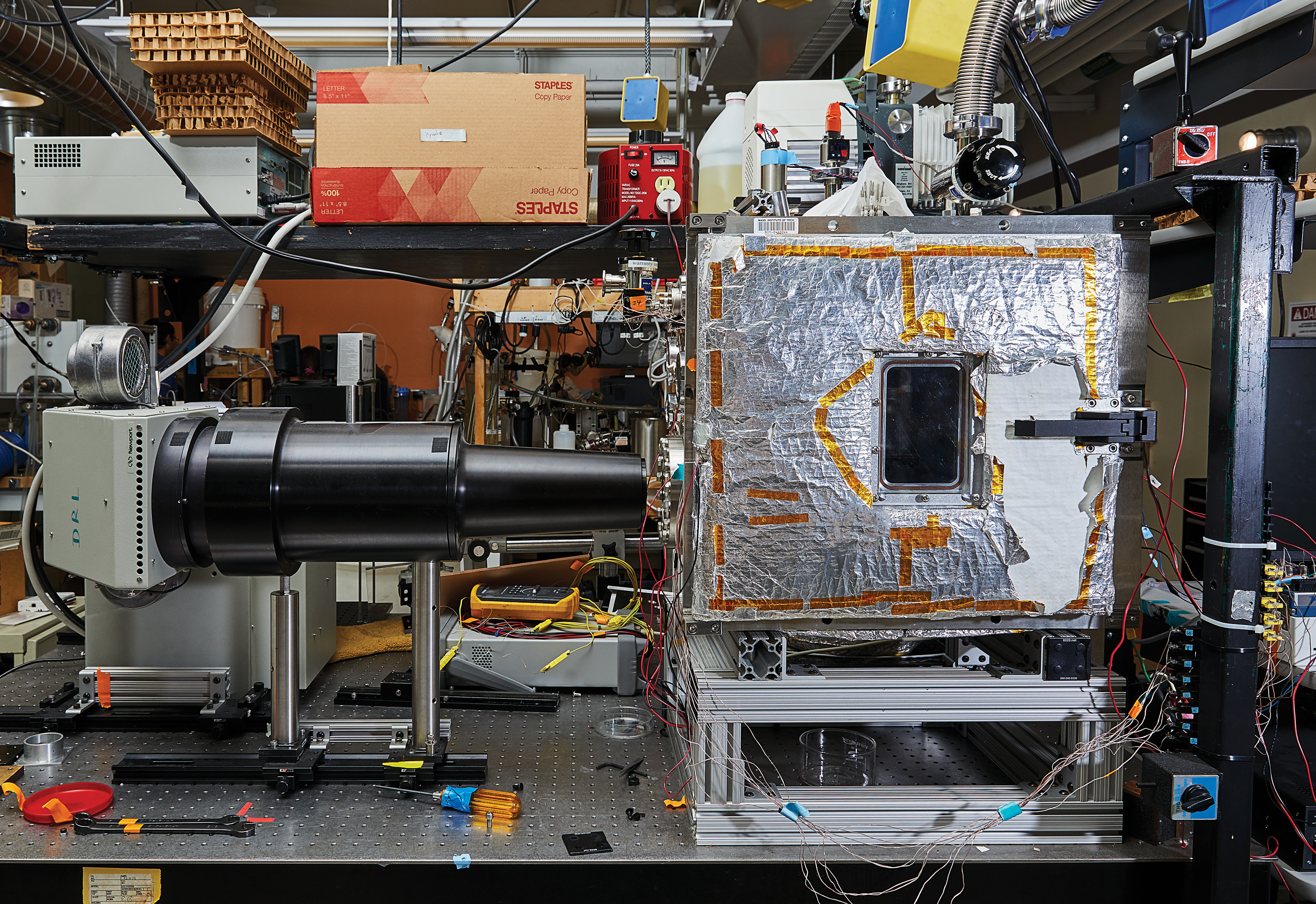 Concentrated light from a solar simulator shines through the window of a vacuum chamber, where it reaches the solar thermophotovoltaic device and generates electricity.