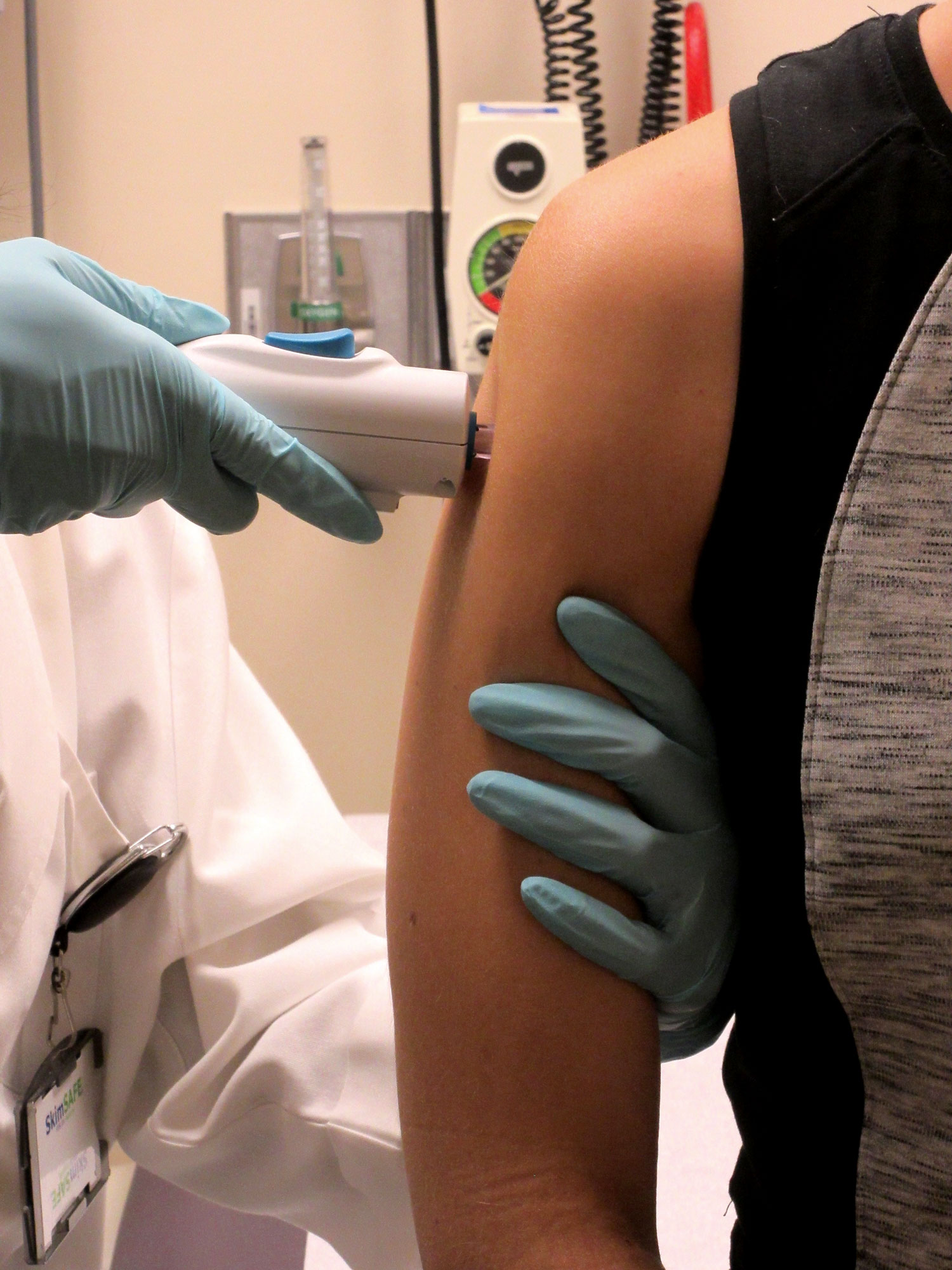 A healthy patient receives an investigational DNA vaccine developed by government researchers via a needle-free injection.