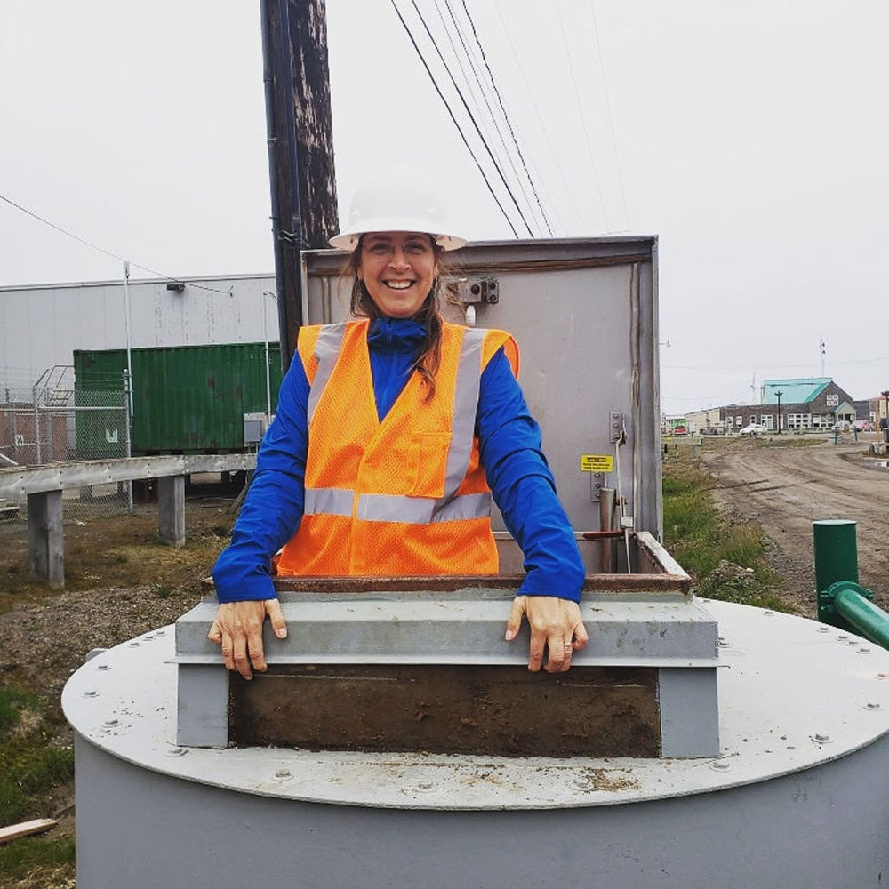 O'Connor standing in the entrance to a utility tunnel in Utqiagvik, Alaska.