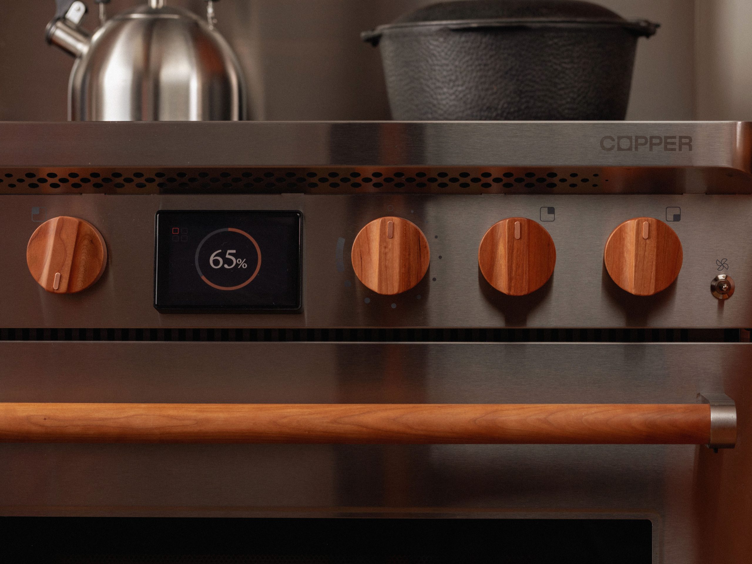 closeup of a stainless steel stove with wood finish buttons and a display that reads